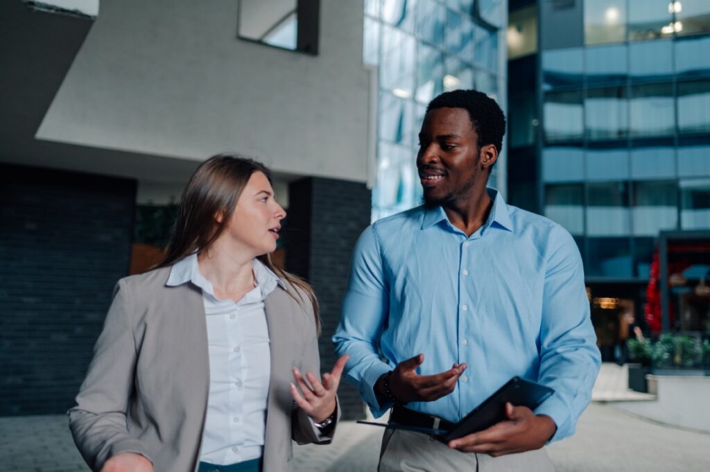 Businesspeople walking and talking outside office building | Cobalt Digital Marketing Two coworkers talking