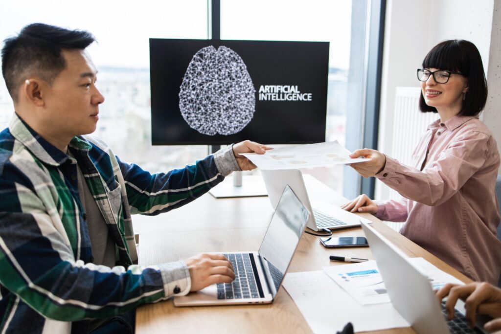 Coworkers collaborating on artificial intelligence project in modern office | Cobalt Digital Marketing A business meeting discussing AI use in business
